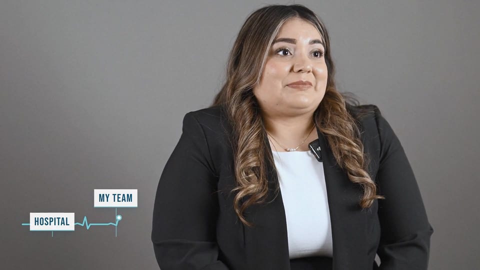 Elizabeth Zamora speaking in a black blazer over a white top, a frame from the film We Save Lives